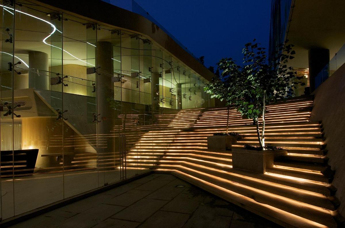 a set of stairs in front of a building with a tree at Vivanta Bengaluru, Whitefield in Bengaluru