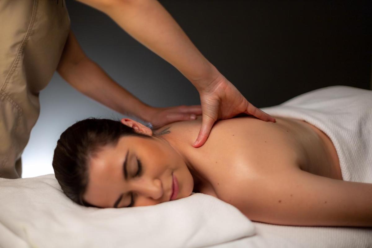 uma mulher recebendo uma massagem de um terapeuta em Casa das Penhas Douradas - Burel Expedition Hotel em Manteigas