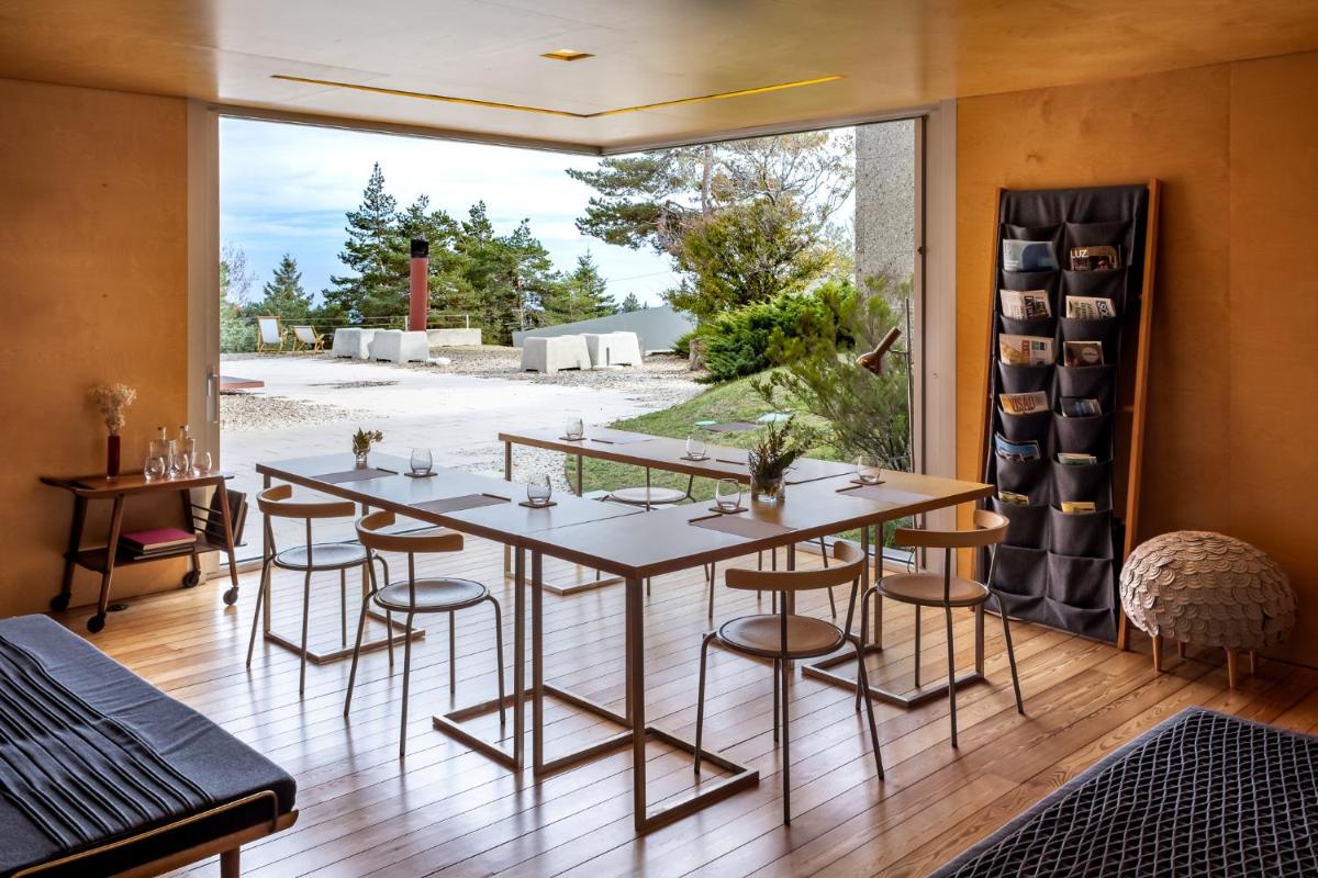uma sala de jantar com mesa e cadeiras e uma grande janela em Casa das Penhas Douradas - Burel Expedition Hotel em Manteigas