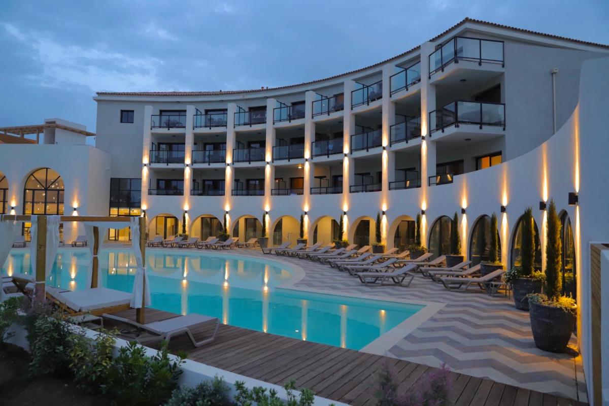 un hôtel avec une piscine devant un immeuble dans l'établissement Eco-Résidence Dolce Paese & Spa, à Algajola un hôtel avec une piscine devant un immeuble dans l'établissement Eco-Résidence Dolce Paese & Spa, à Algajola