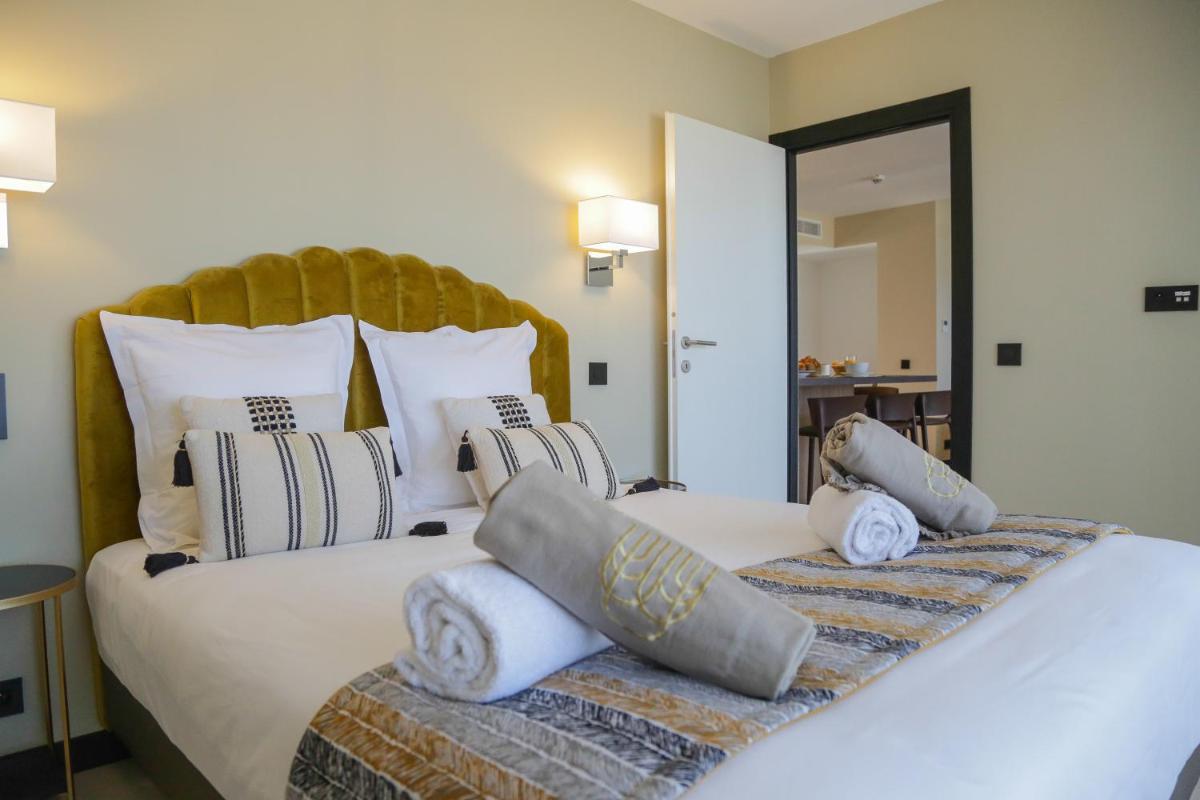 une chambre avec un grand lit blanc et des oreillers dans l'établissement Eco-Résidence Dolce Paese & Spa, à Algajola 57 autres photos