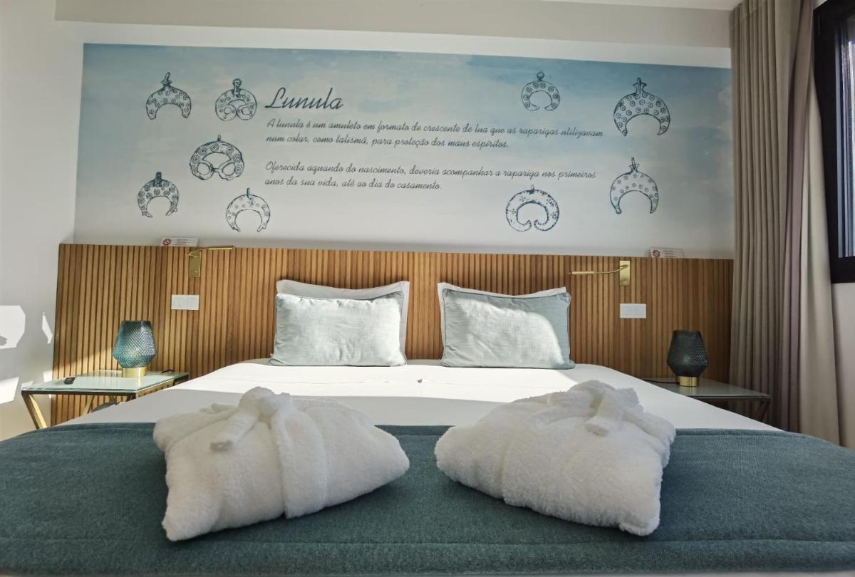 um quarto com uma cama com duas toalhas em Castelo Hotel em Chaves