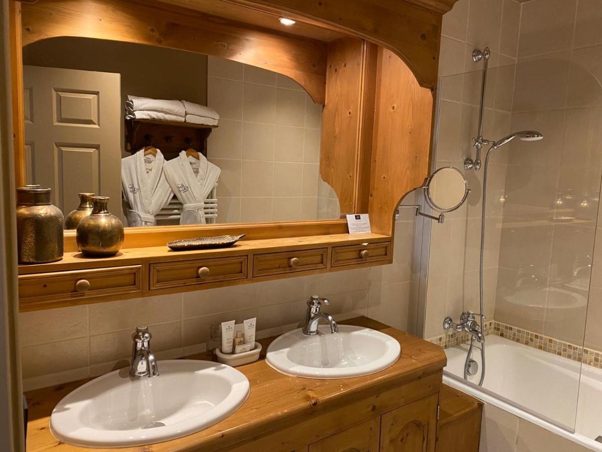 une salle de bain avec deux lavabos, un miroir et une baignoire dans l'établissement Hôtel Spa Vent d'Ouest, au Havre 28 autres photos