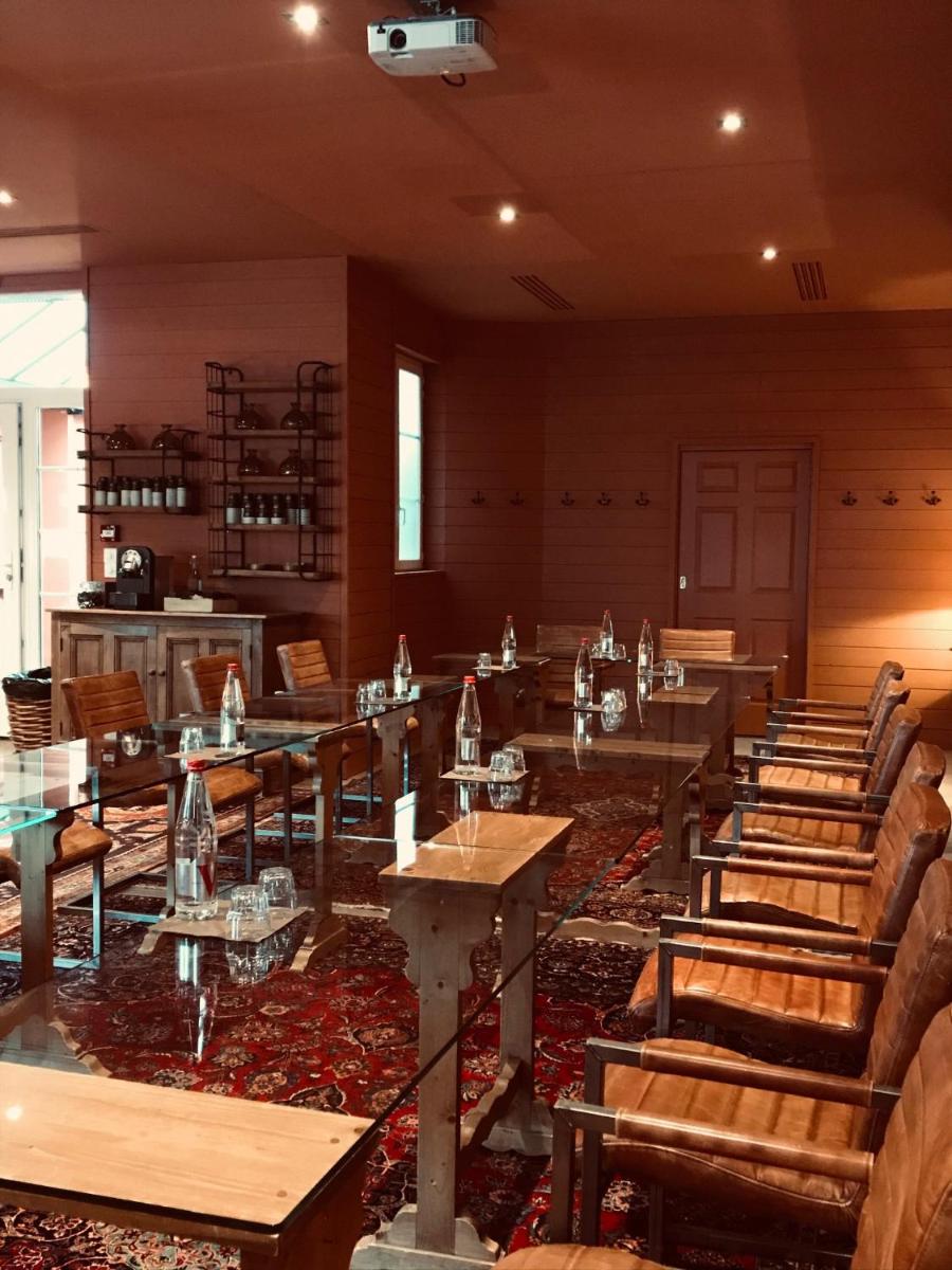 un restaurant avec des tables et des chaises en bois dans une salle dans l'établissement Hôtel Spa Vent d'Ouest, au Havre
