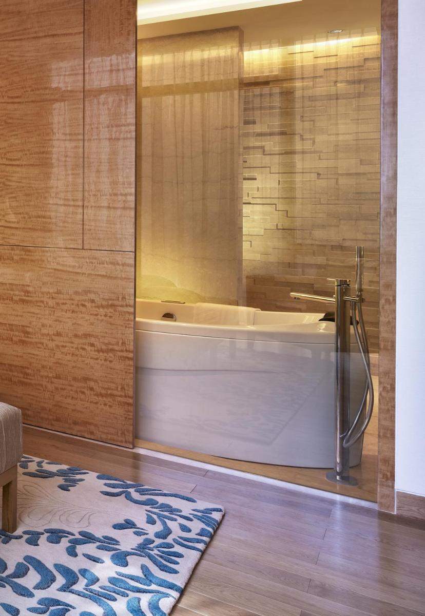 a bath tub in a bathroom with a rug at Taj City Centre Gurugram in Gurgaon