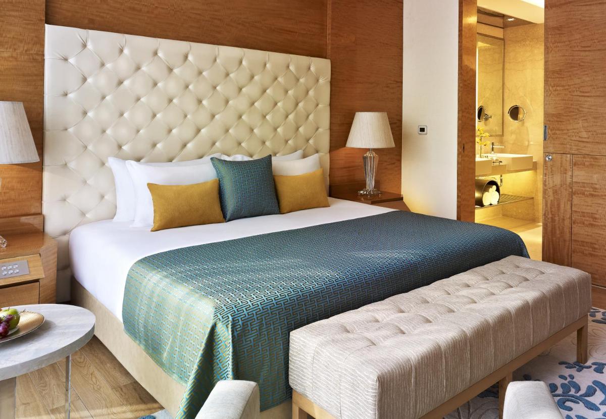a bedroom with a large bed and a bathroom at Taj City Centre Gurugram in Gurgaon