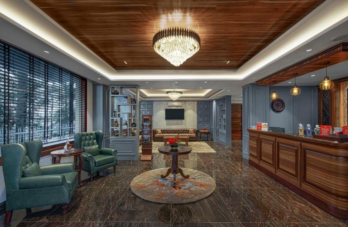 a lobby with a waiting room with chairs and a tv at WelcomHeritage Elysium Resort & Spa in Shimla