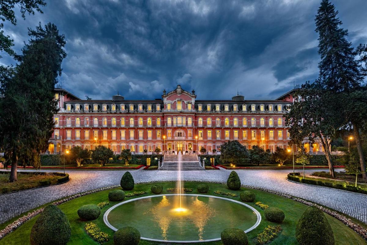 um grande edifício com uma fonte em frente em Vidago Palace em Vidago