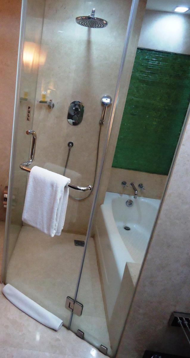 a bathroom with a shower with a tub and a sink at Radisson Blu Atria Bengaluru in Bengaluru a bathroom with a shower with a tub and a sink at Radisson Blu Atria Bengaluru in Bengaluru