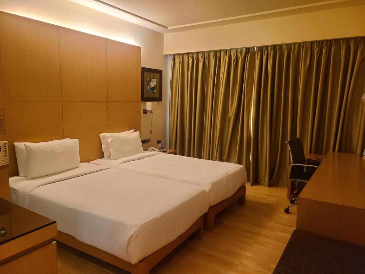 a hotel room with a large bed and a desk at Novotel Hyderabad Airport in Hyderabad