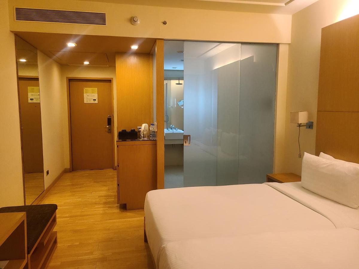 a hotel room with a bed and a bathroom at Novotel Hyderabad Airport in Hyderabad
