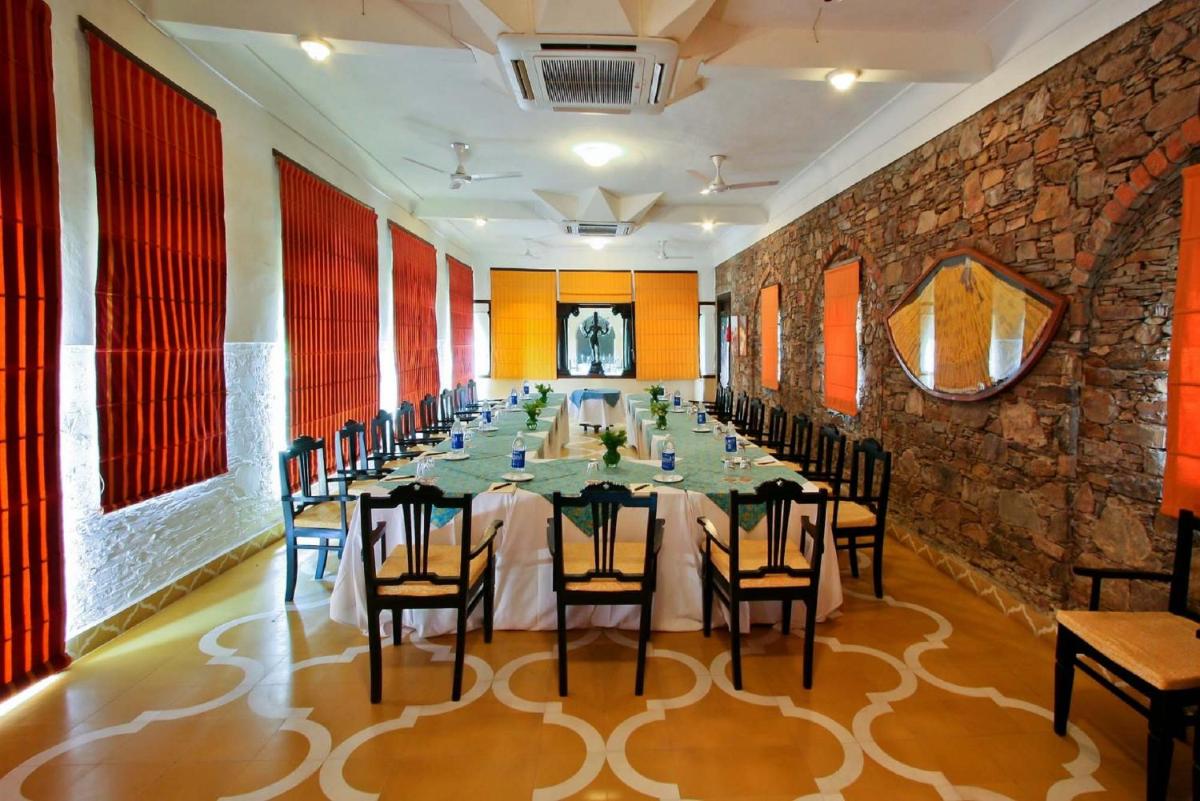 a long dining room with a long table and chairs at Neemrana Fort-Palace in Neemrana