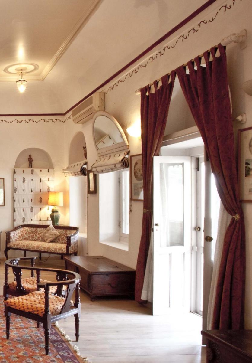 a bedroom with a bed and a door with a window at Neemrana Fort-Palace in Neemrana