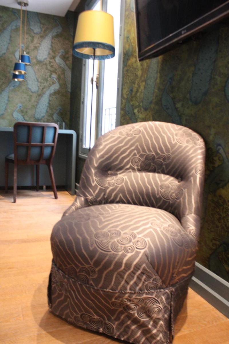 un fauteuil en cuir brun assis dans le salon dans l'établissement Monsieur Cadet Hotel & Spa, à Paris