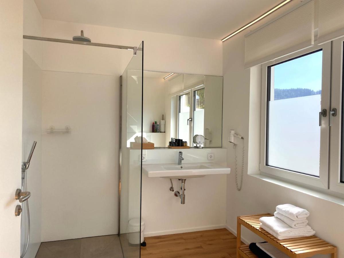 ein Badezimmer mit Waschbecken und Glasdusche in der Unterkunft Weingut-Aparthotel Olinger in Mehring