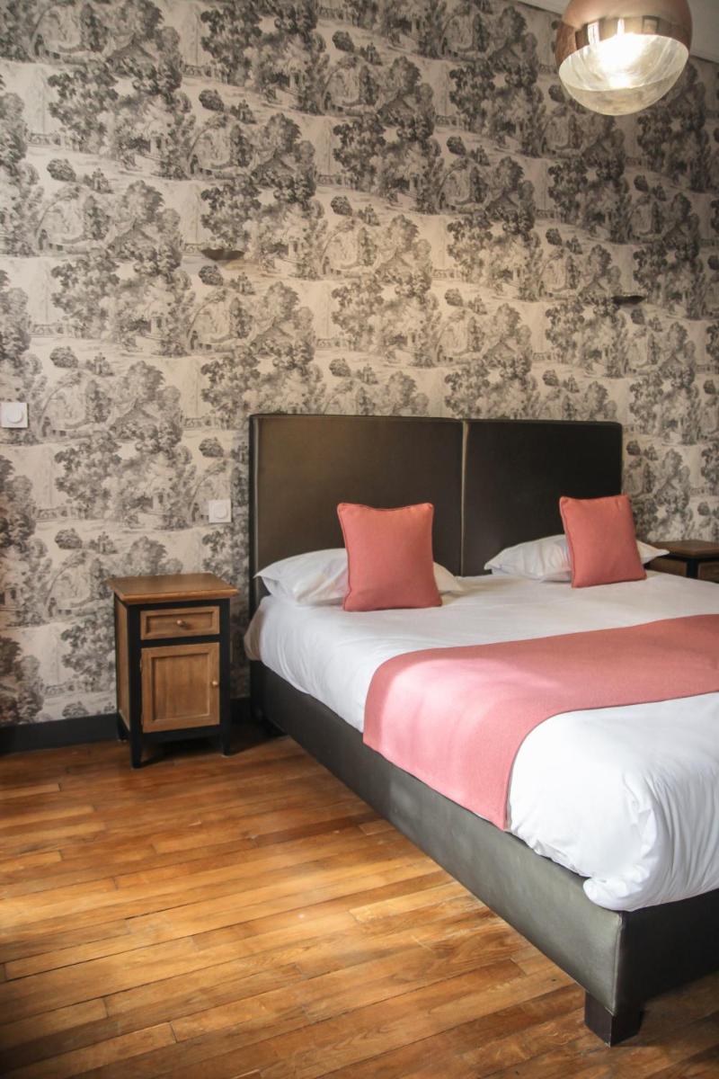 Un ou plusieurs lits dans un hébergement de l'établissement Hôtel Le Petit Périer
