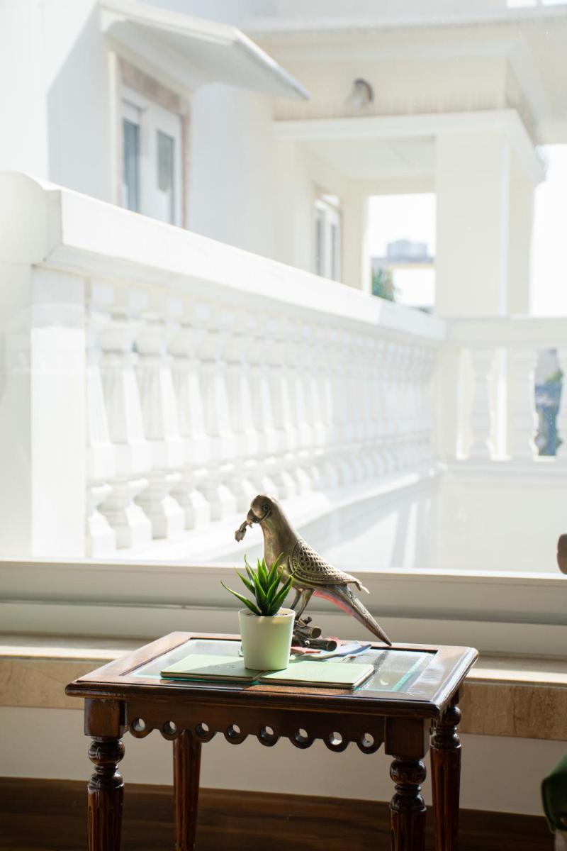 a small bird sitting on a table next to a cup at Dileep Kothi - A Royal Boutique Luxury Suites in Jaipur in Jaipur
