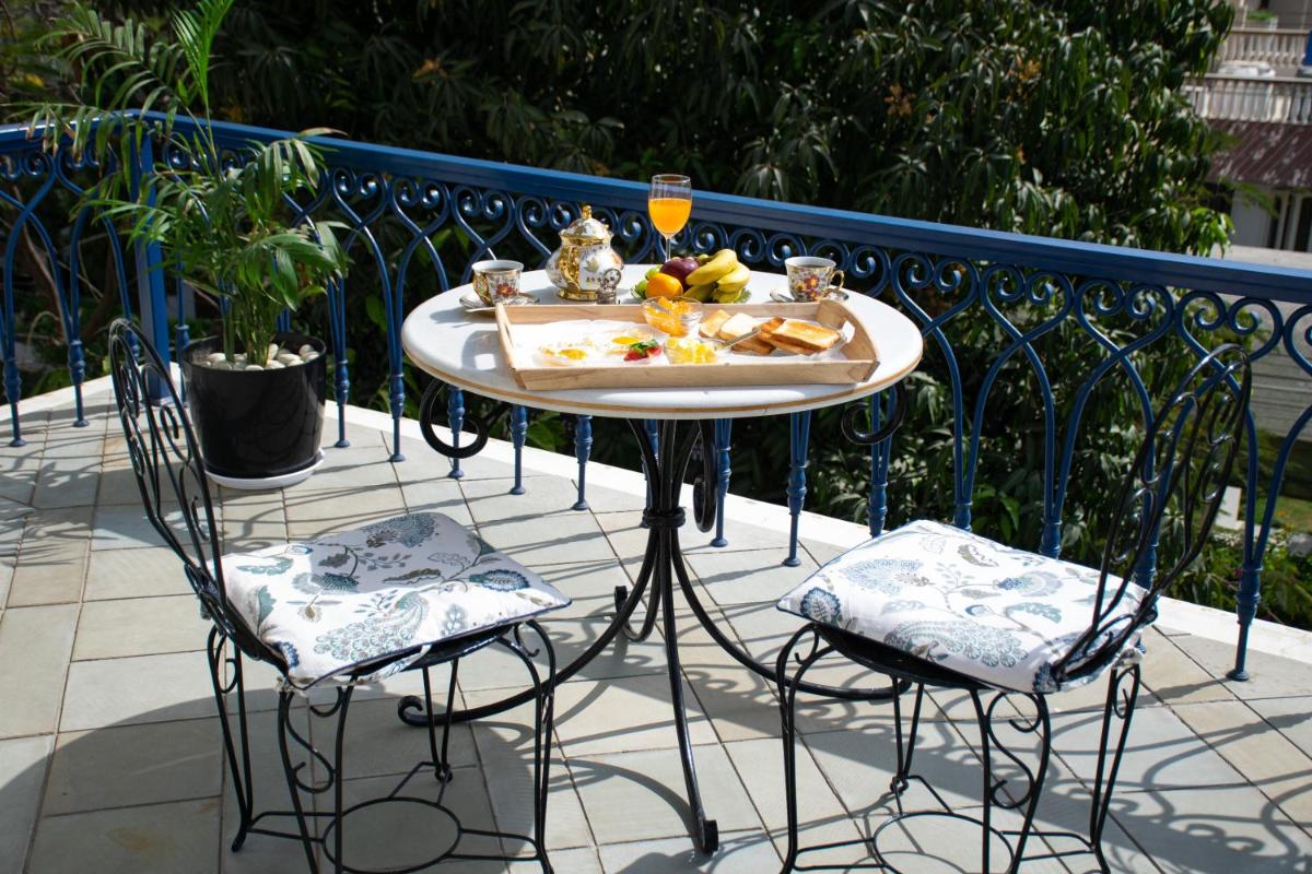 a table with a tray of food and two chairs at Dileep Kothi - A Royal Boutique Luxury Suites in Jaipur in Jaipur