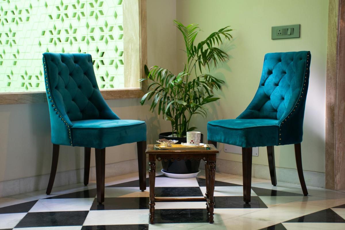 two chairs in a room with a table at Dileep Kothi - A Royal Boutique Luxury Suites in Jaipur in Jaipur