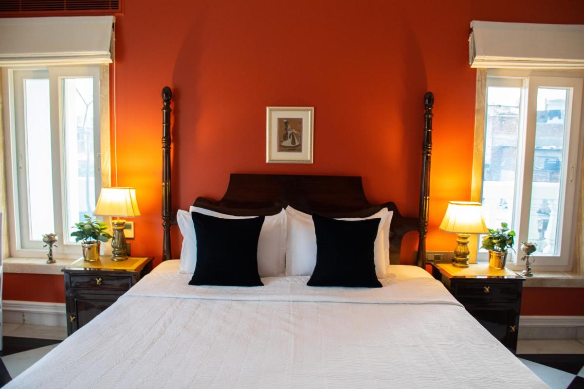 a bedroom with a large bed with an orange wall at Dileep Kothi - A Royal Boutique Luxury Suites in Jaipur in Jaipur