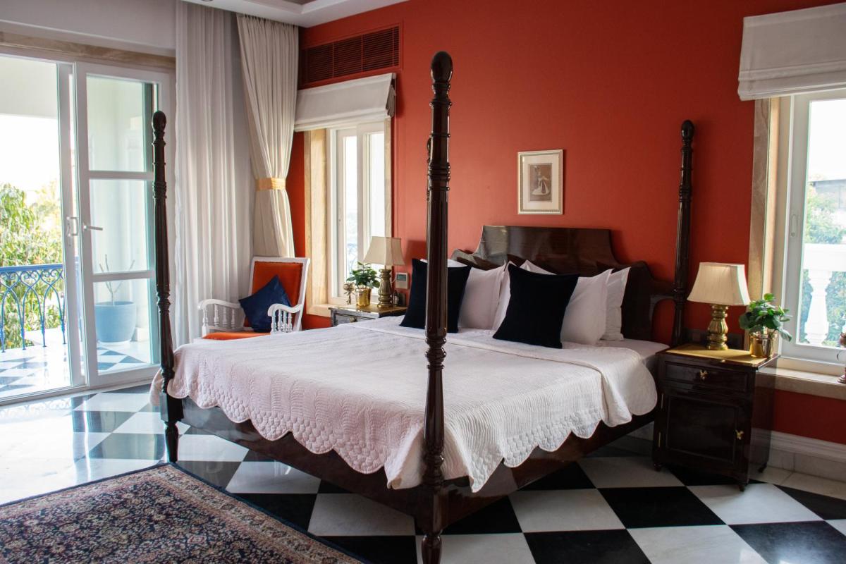 a bedroom with a large bed with red walls at Dileep Kothi - A Royal Boutique Luxury Suites in Jaipur in Jaipur