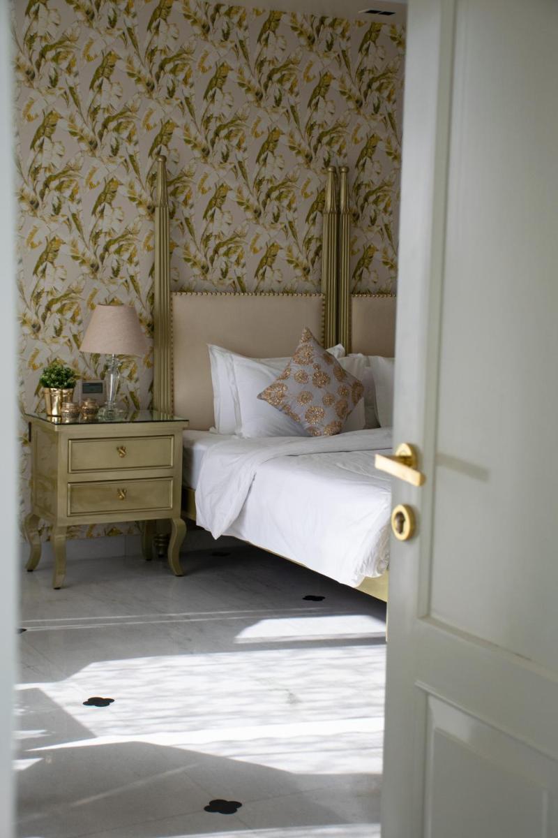 a bedroom with a bed and a table with a lamp at Dileep Kothi - A Royal Boutique Luxury Suites in Jaipur in Jaipur