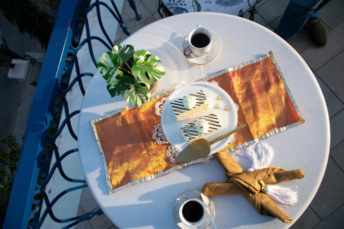 a white table with a plate and two cups of coffee at Dileep Kothi - A Royal Boutique Luxury Suites in Jaipur in Jaipur