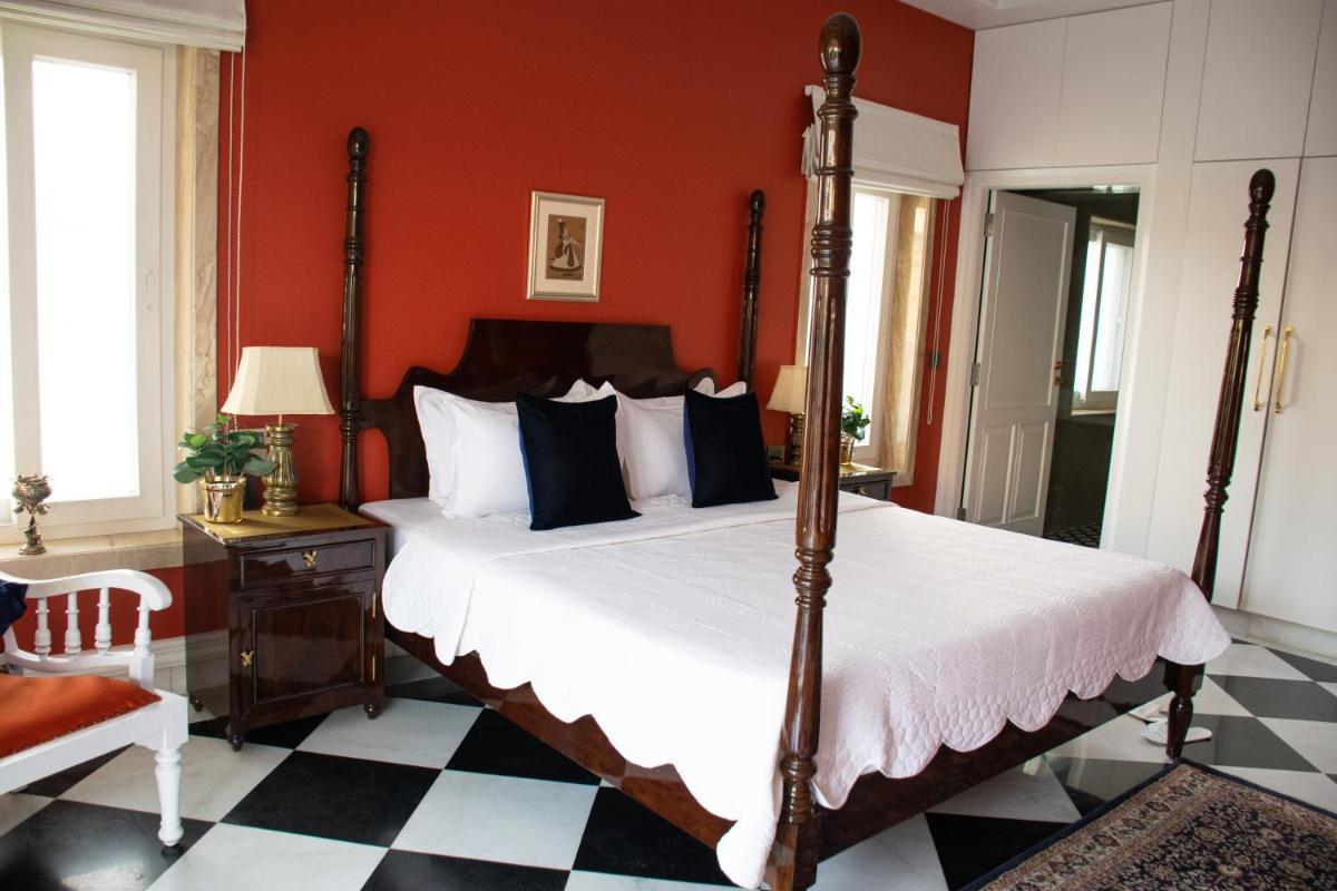 a bedroom with a bed and a red wall at Dileep Kothi - A Royal Boutique Luxury Suites in Jaipur in Jaipur