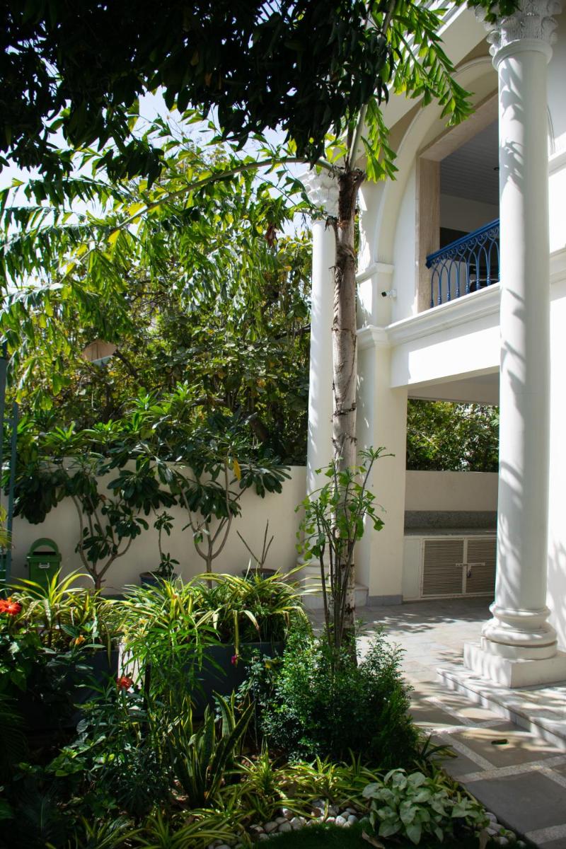 a building with columns and plants in a courtyard at Dileep Kothi - A Royal Boutique Luxury Suites in Jaipur in Jaipur