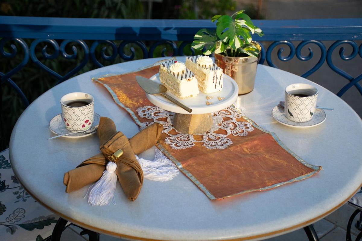 a table with a cake and two cups on it at Dileep Kothi - A Royal Boutique Luxury Suites in Jaipur in Jaipur