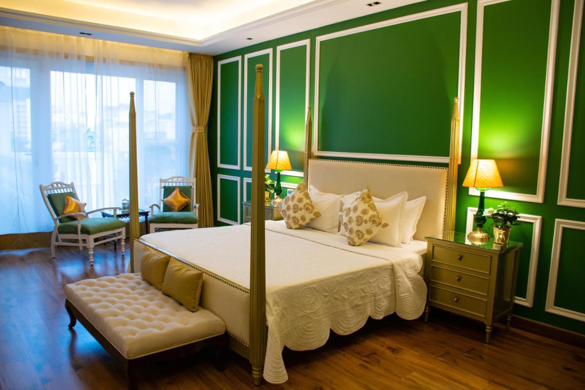 a bedroom with a bed and a green wall at Dileep Kothi - A Royal Boutique Luxury Suites in Jaipur in Jaipur