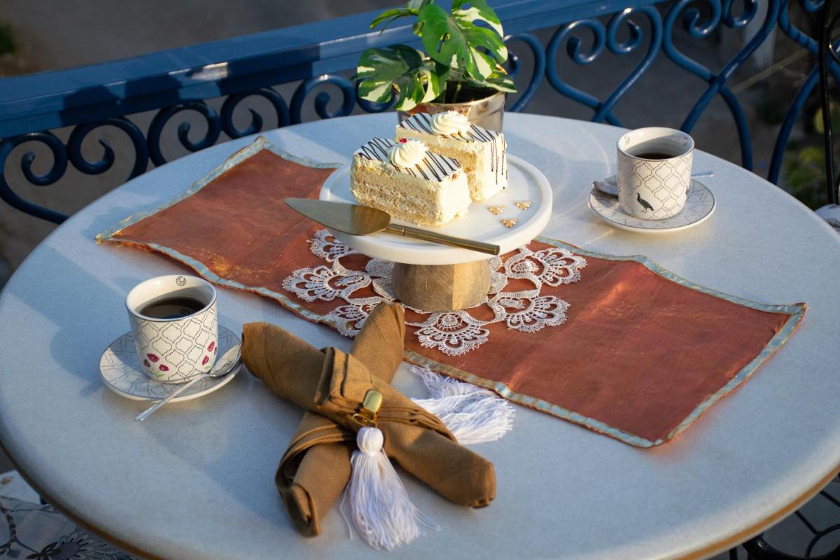 a table with a cake and two cups of coffee at Dileep Kothi - A Royal Boutique Luxury Suites in Jaipur in Jaipur