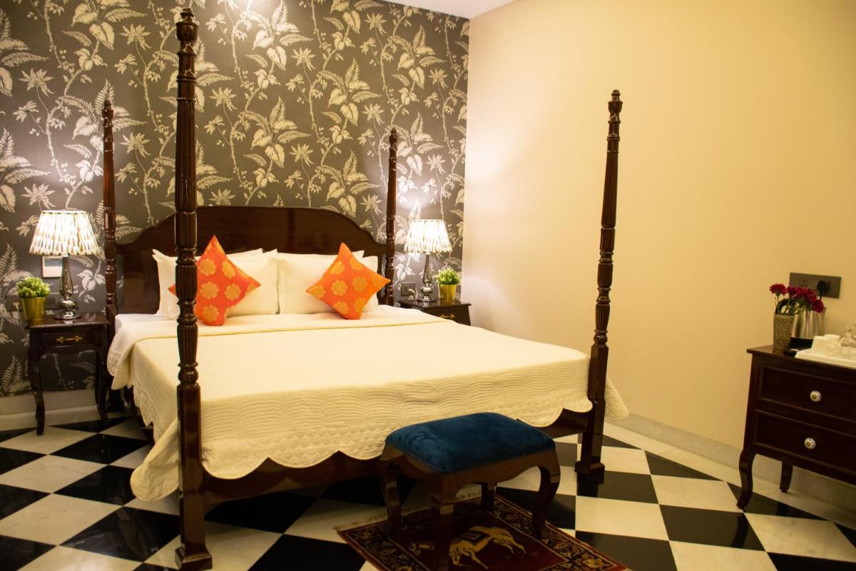 a bedroom with a bed and a black and white checkered floor at Dileep Kothi - A Royal Boutique Luxury Suites in Jaipur in Jaipur