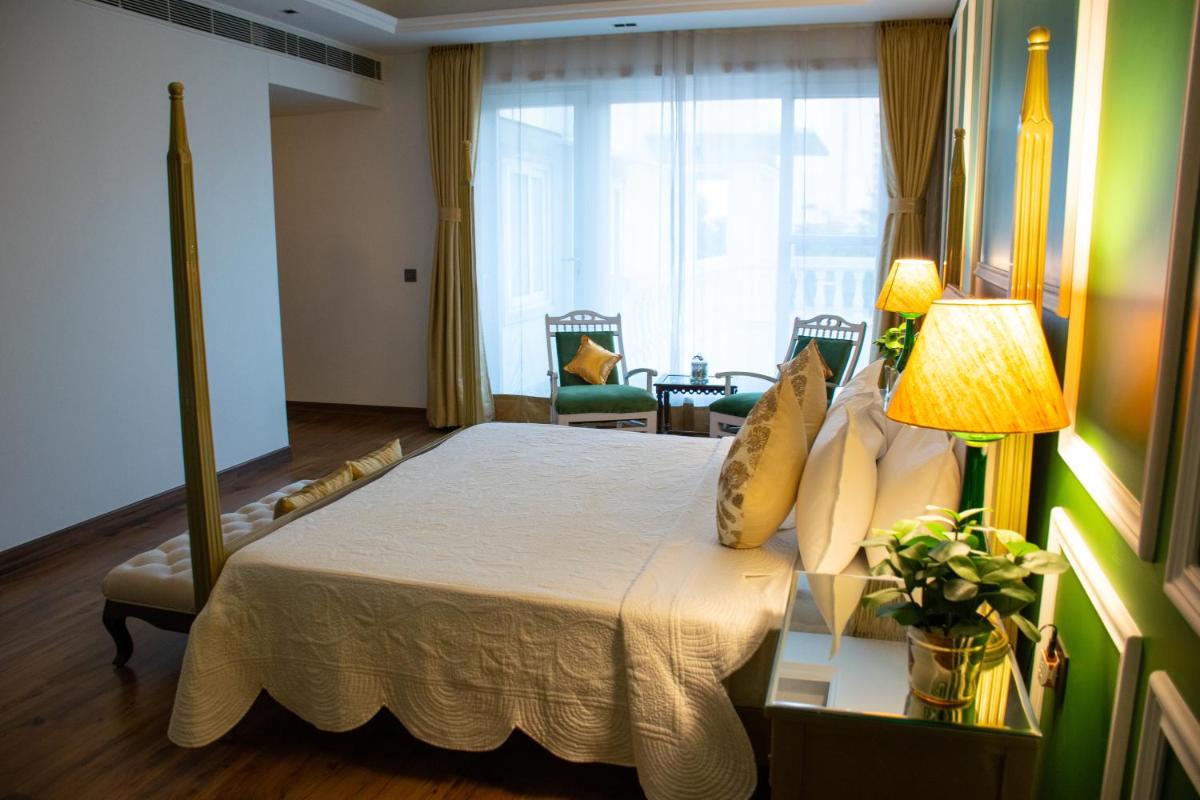 a bedroom with a bed with a lamp and a window at Dileep Kothi - A Royal Boutique Luxury Suites in Jaipur in Jaipur