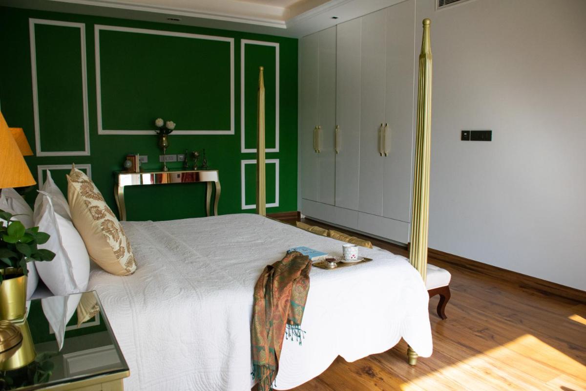 a bedroom with green walls and a white bed at Dileep Kothi - A Royal Boutique Luxury Suites in Jaipur in Jaipur
