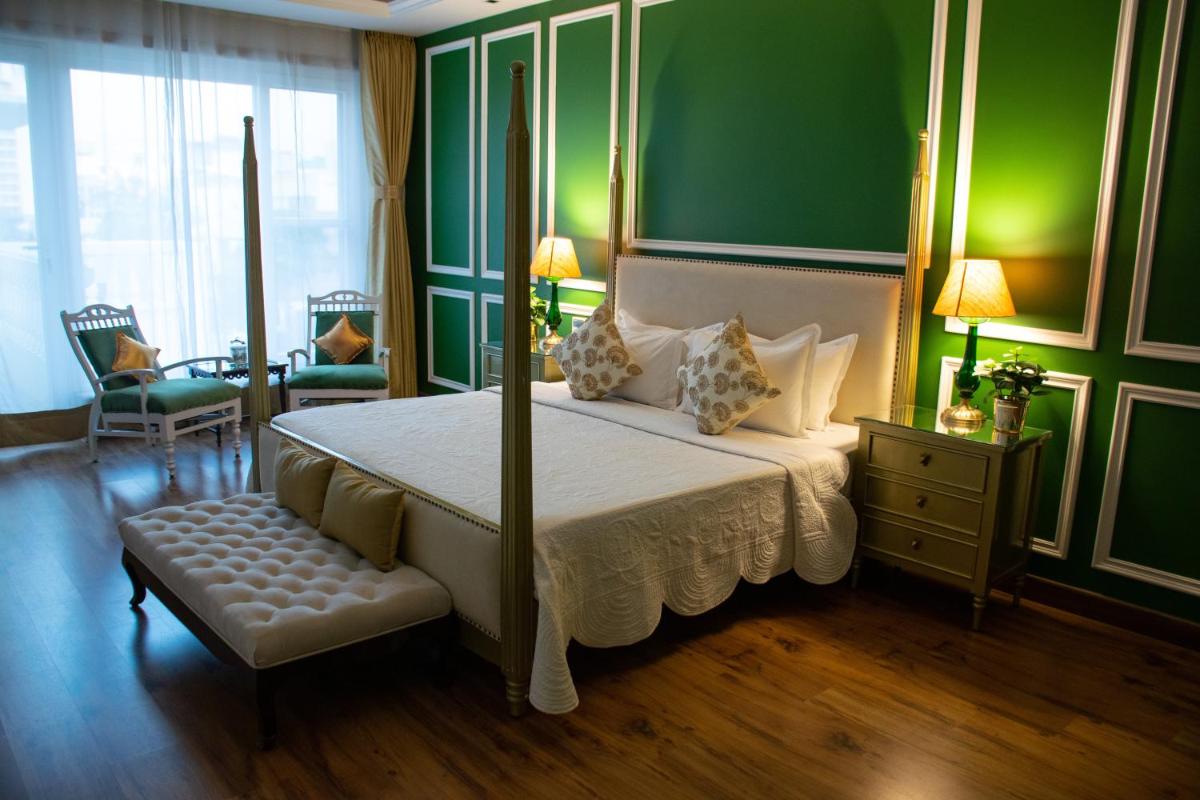a bedroom with a large bed and a green wall at Dileep Kothi - A Royal Boutique Luxury Suites in Jaipur in Jaipur