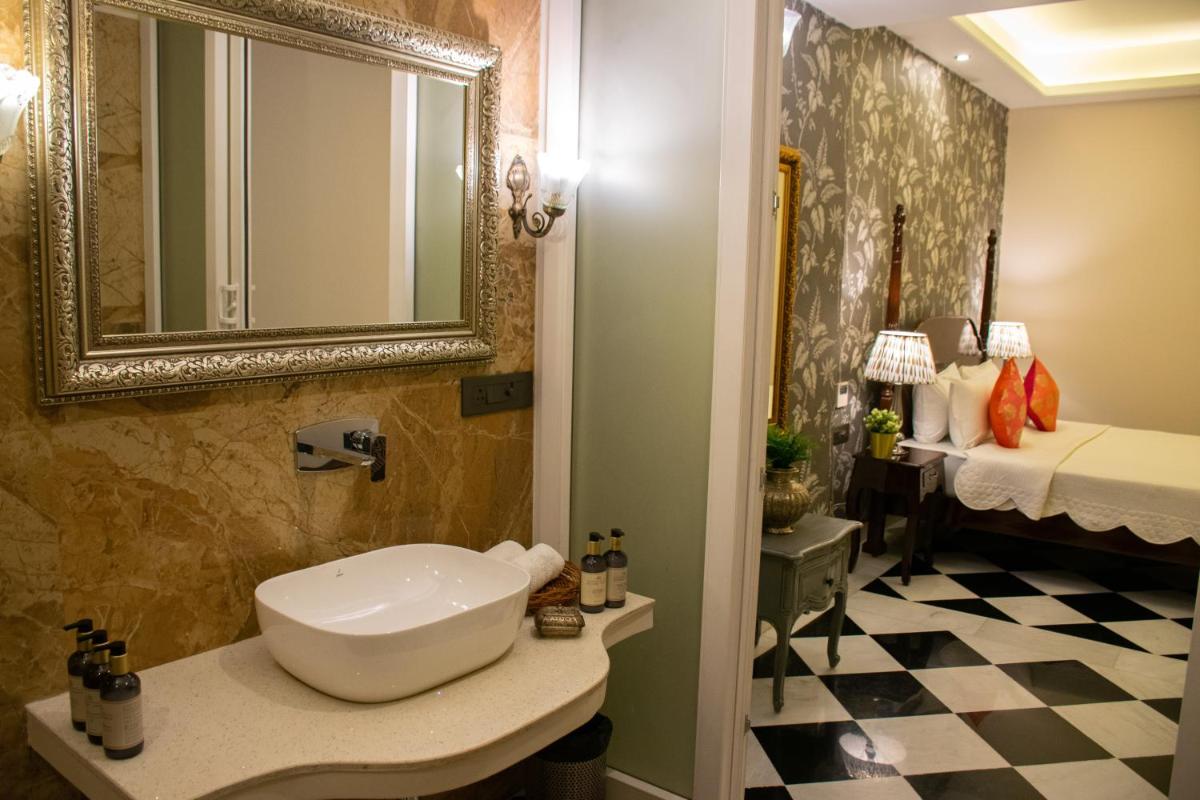 a bathroom with a sink and a mirror and a bed at Dileep Kothi - A Royal Boutique Luxury Suites in Jaipur in Jaipur