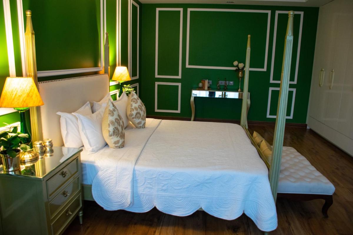 a bedroom with green walls and a bed with white sheets at Dileep Kothi - A Royal Boutique Luxury Suites in Jaipur in Jaipur