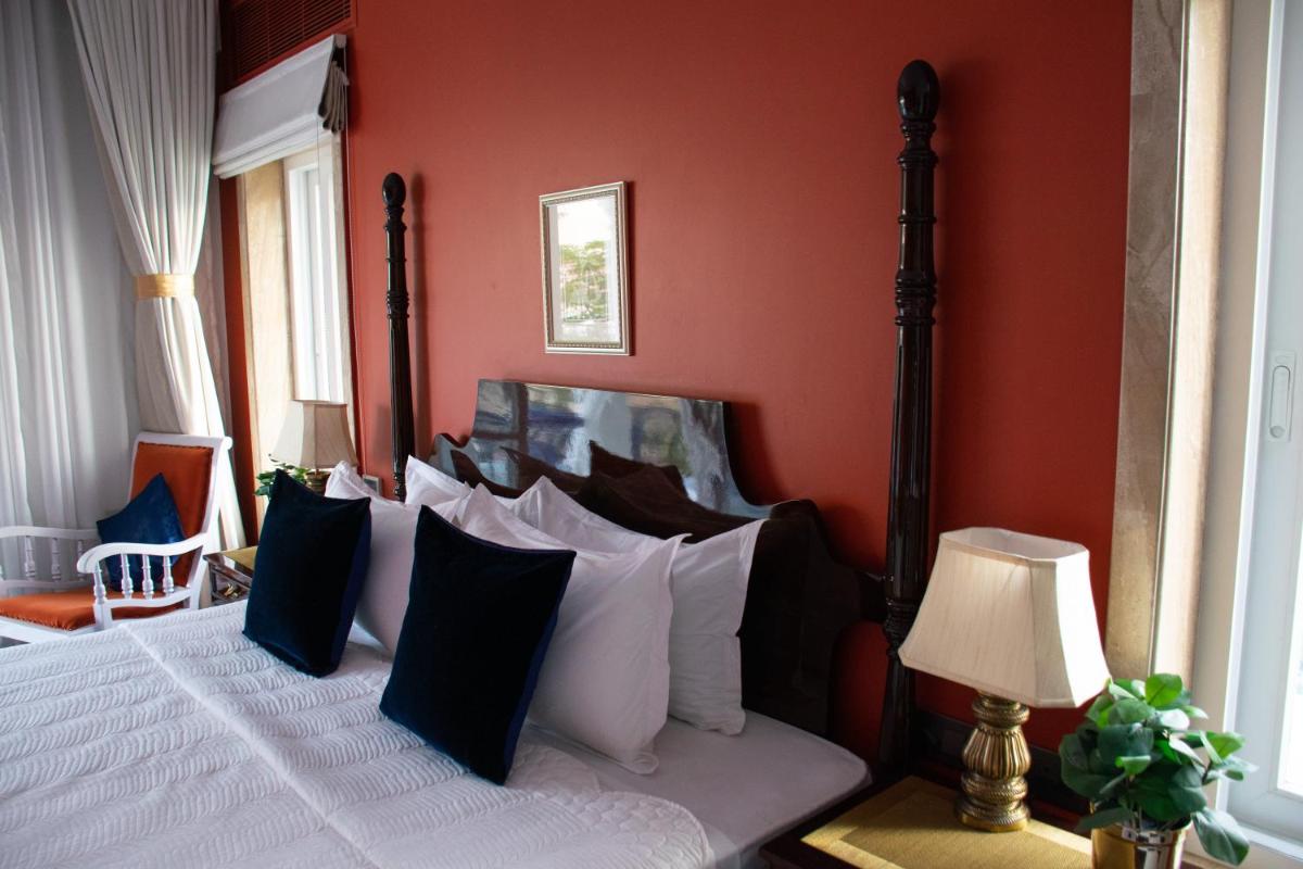a bedroom with a bed with black and white pillows at Dileep Kothi - A Royal Boutique Luxury Suites in Jaipur in Jaipur