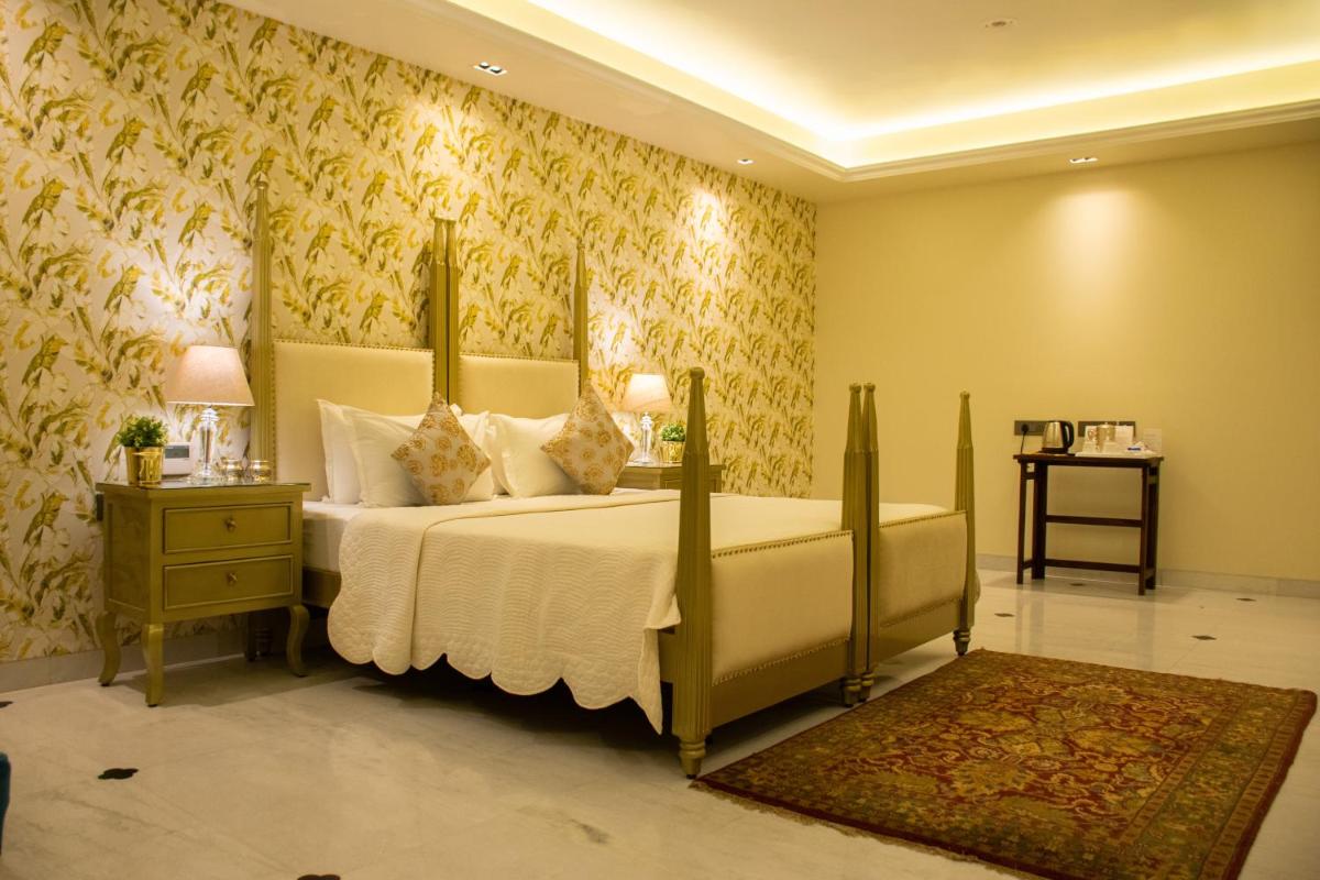 a bedroom with a large bed with yellow wallpaper at Dileep Kothi - A Royal Boutique Luxury Suites in Jaipur in Jaipur