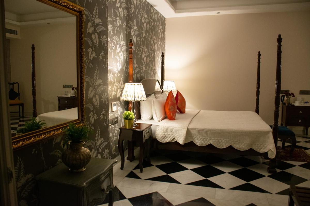 a bedroom with a bed and a mirror at Dileep Kothi - A Royal Boutique Luxury Suites in Jaipur in Jaipur