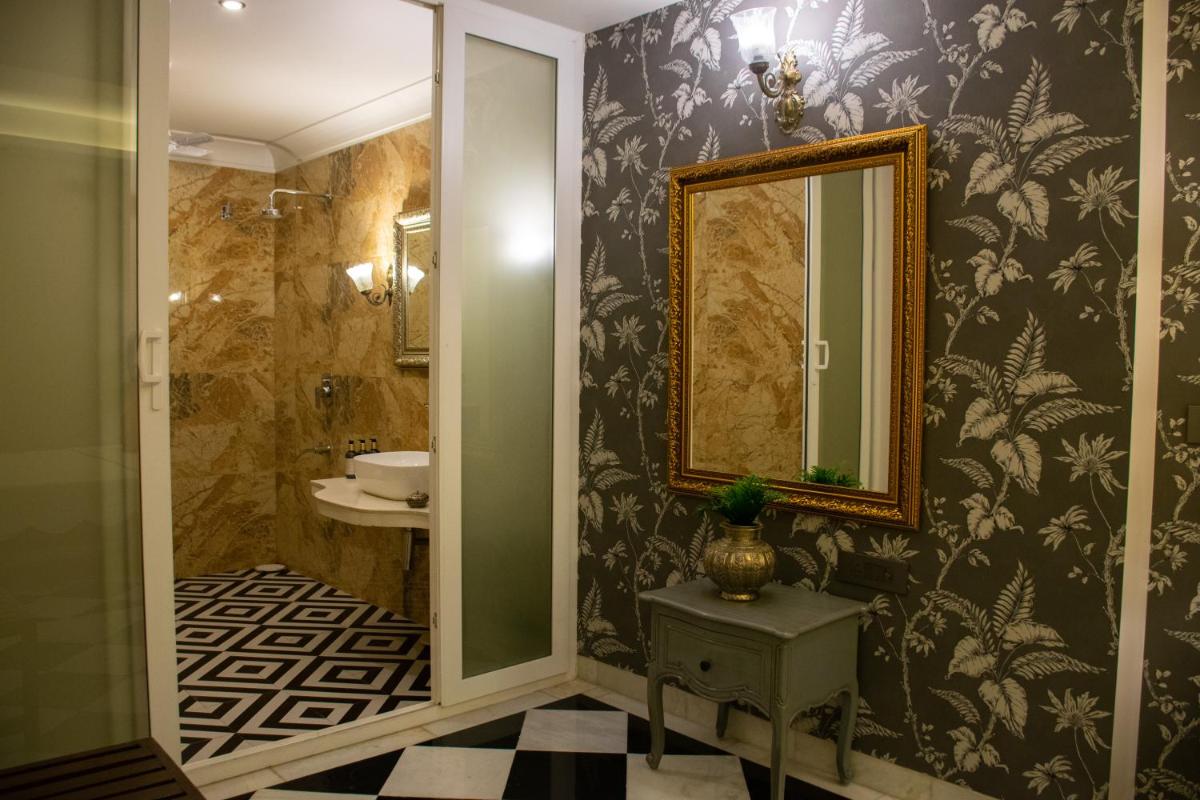 a bathroom with a mirror and a sink at Dileep Kothi - A Royal Boutique Luxury Suites in Jaipur in Jaipur