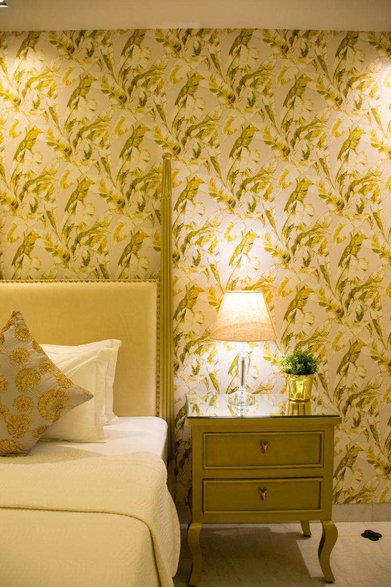 a bedroom with a bed and a table with a lamp at Dileep Kothi - A Royal Boutique Luxury Suites in Jaipur in Jaipur