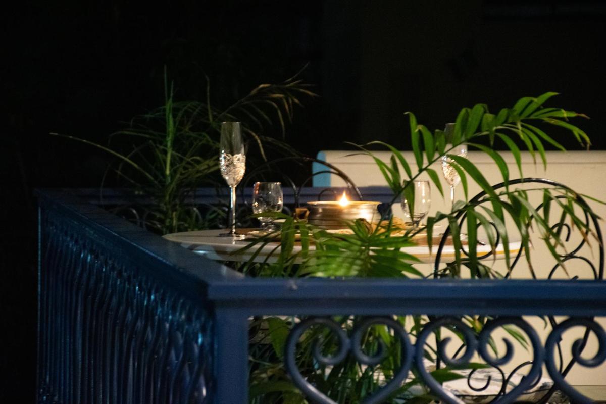 a table with wine glasses and plants on a fence at Dileep Kothi - A Royal Boutique Luxury Suites in Jaipur in Jaipur
