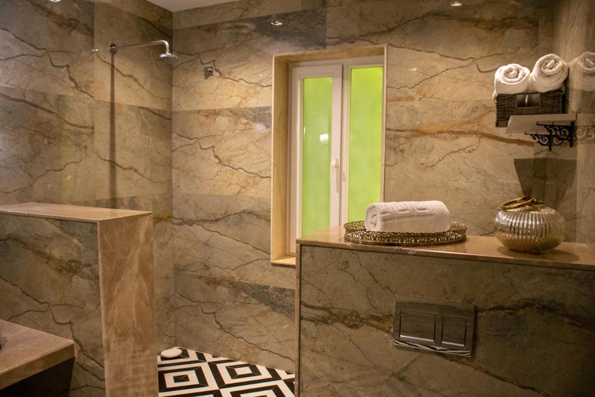 a bathroom with a shower with a sink and a mirror at Dileep Kothi - A Royal Boutique Luxury Suites in Jaipur in Jaipur