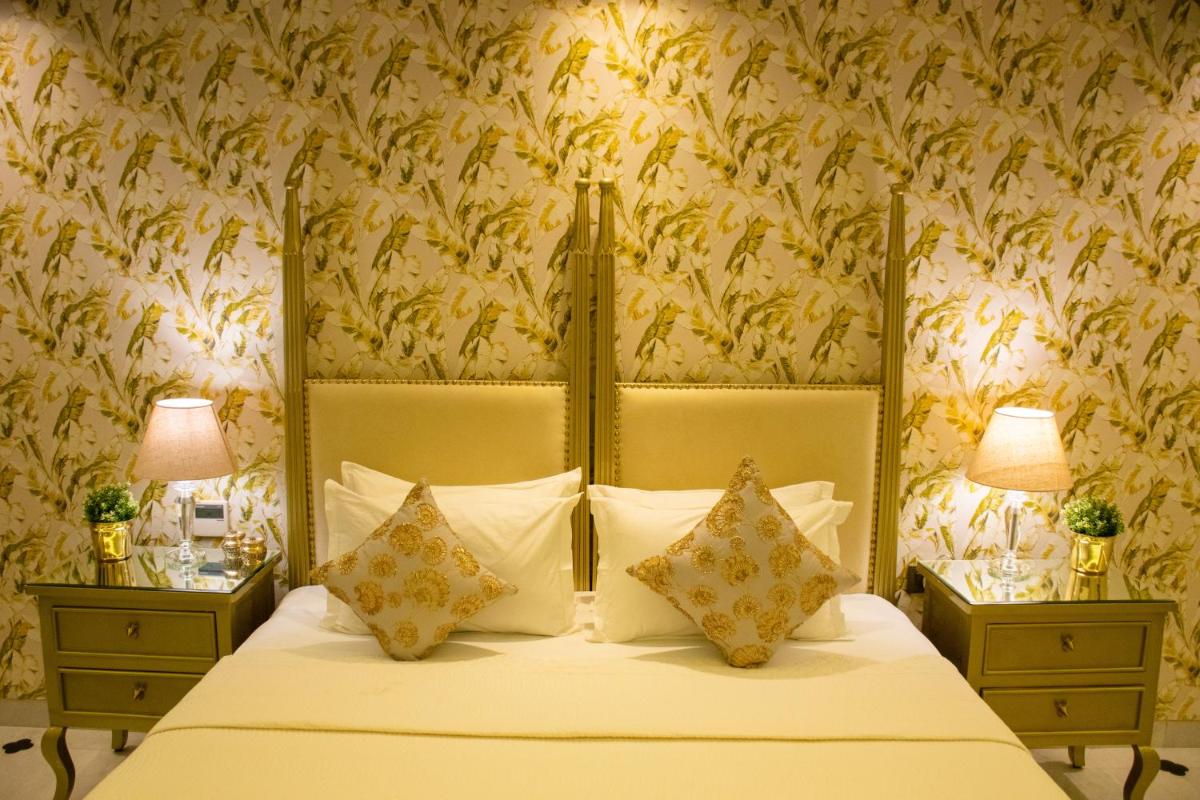 a bedroom with a bed with two night tables and two lamps at Dileep Kothi - A Royal Boutique Luxury Suites in Jaipur in Jaipur