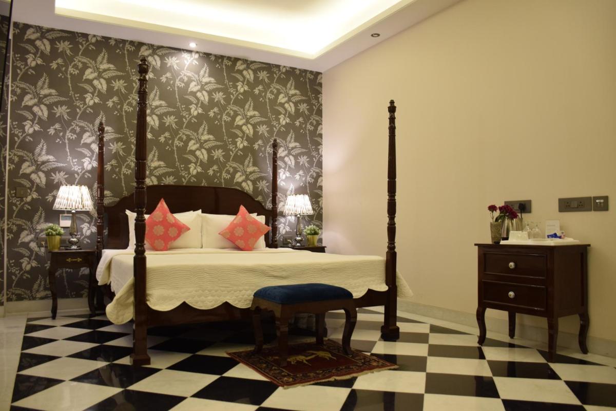 a bedroom with a bed and a black and white checkered floor at Dileep Kothi - A Royal Boutique Luxury Suites in Jaipur in Jaipur