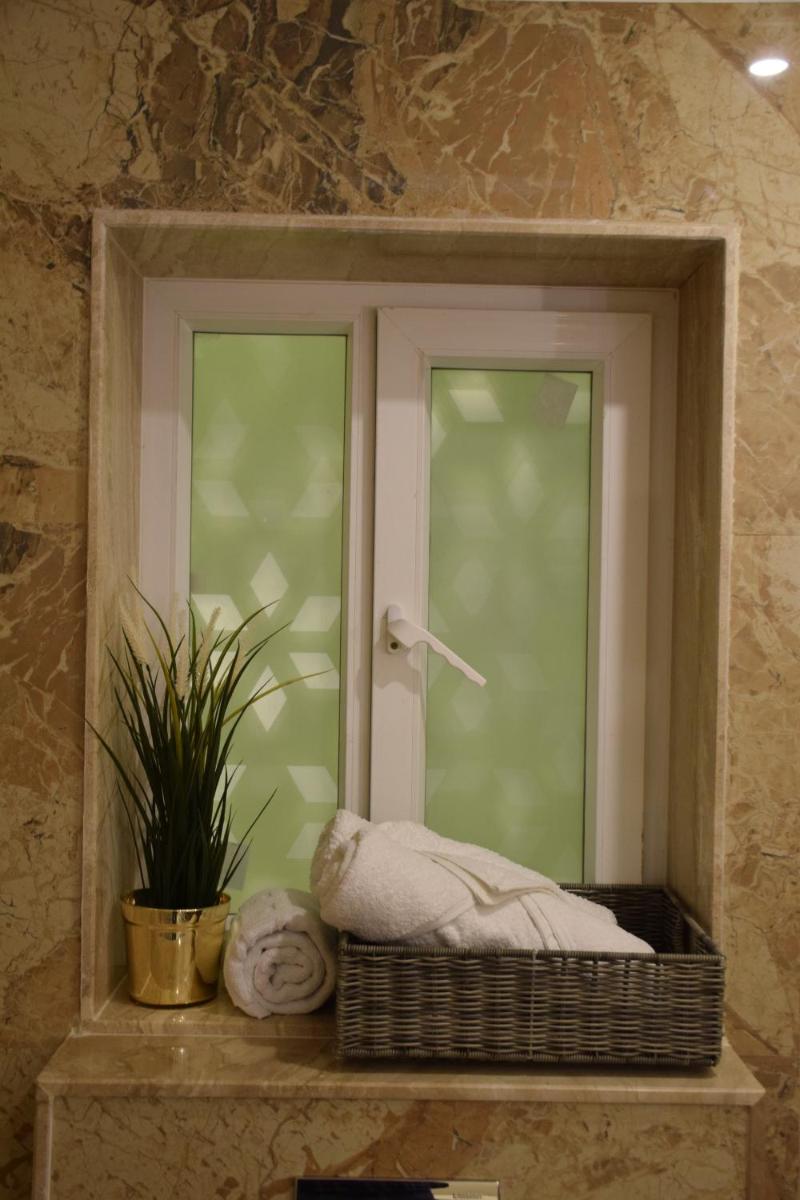 a window with a pillow and a plant on a shelf at Dileep Kothi - A Royal Boutique Luxury Suites in Jaipur in Jaipur