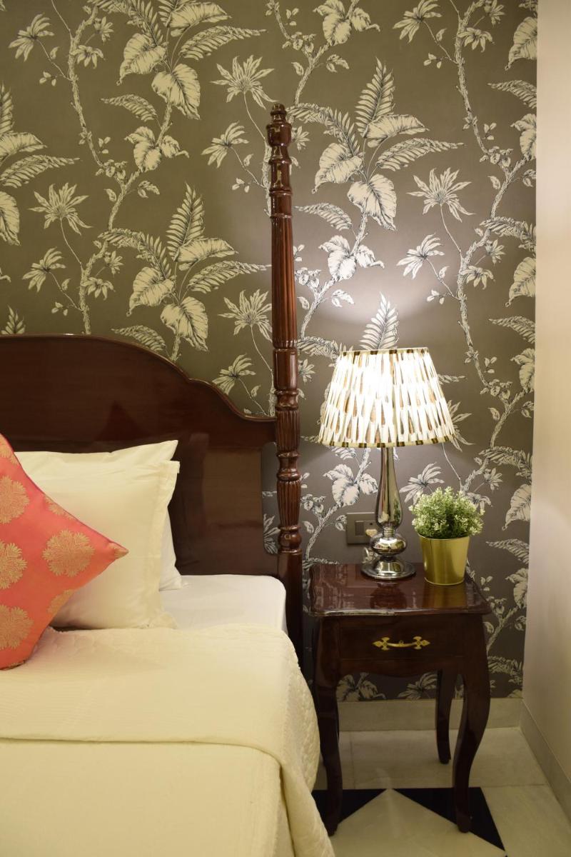 a bedroom with a bed and a table with a lamp at Dileep Kothi - A Royal Boutique Luxury Suites in Jaipur in Jaipur