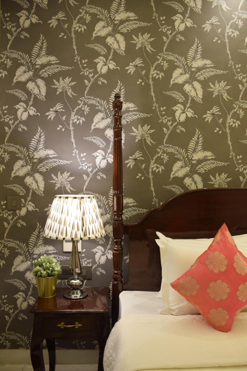 a bedroom with a bed and a table with a lamp at Dileep Kothi - A Royal Boutique Luxury Suites in Jaipur in Jaipur